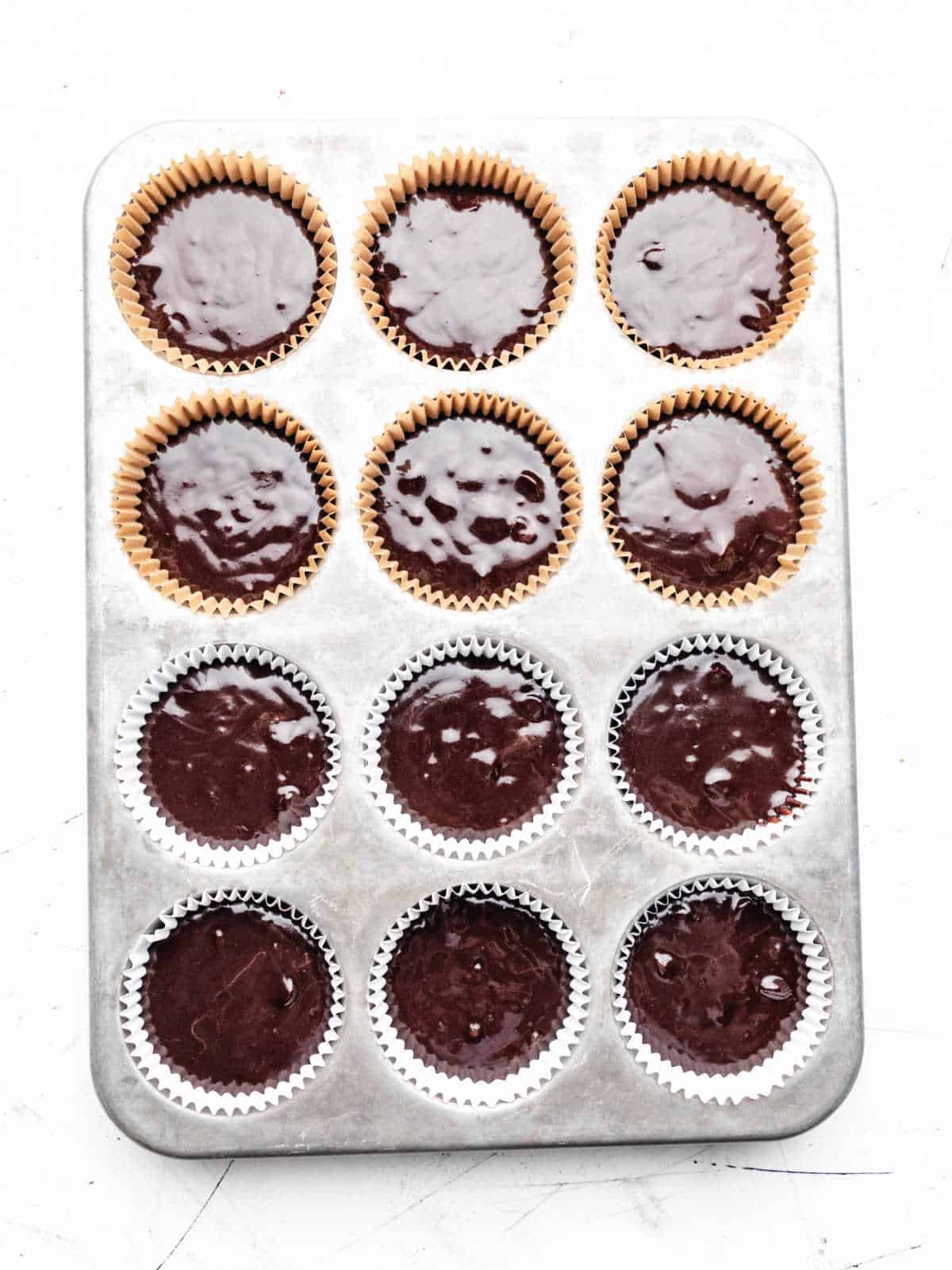 Double chocolate muffin batter in a muffin tin. 