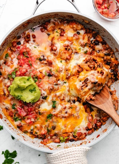 A wooden spoon holding a scoop of Mexican ground beef and rice.