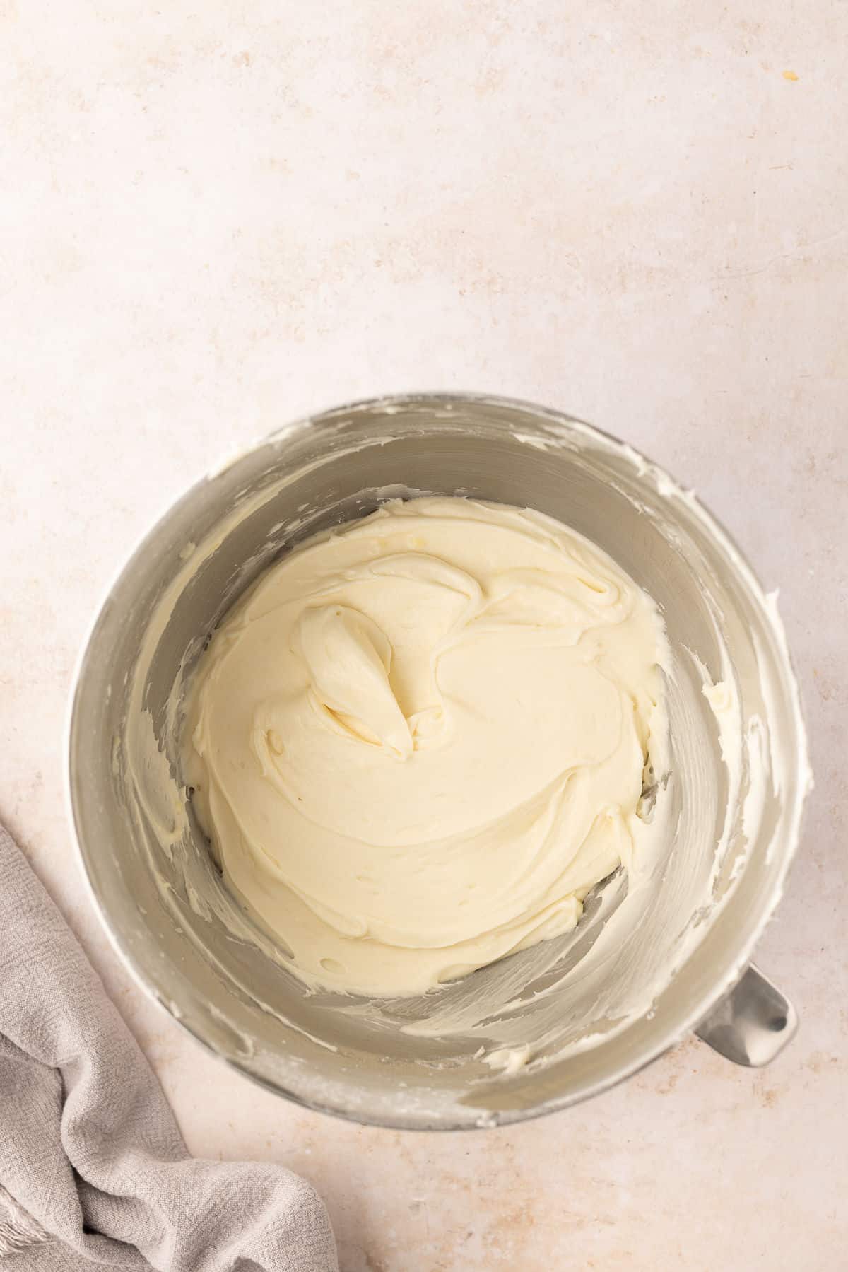 Cream cheese frosting in a silver mixing bowl.