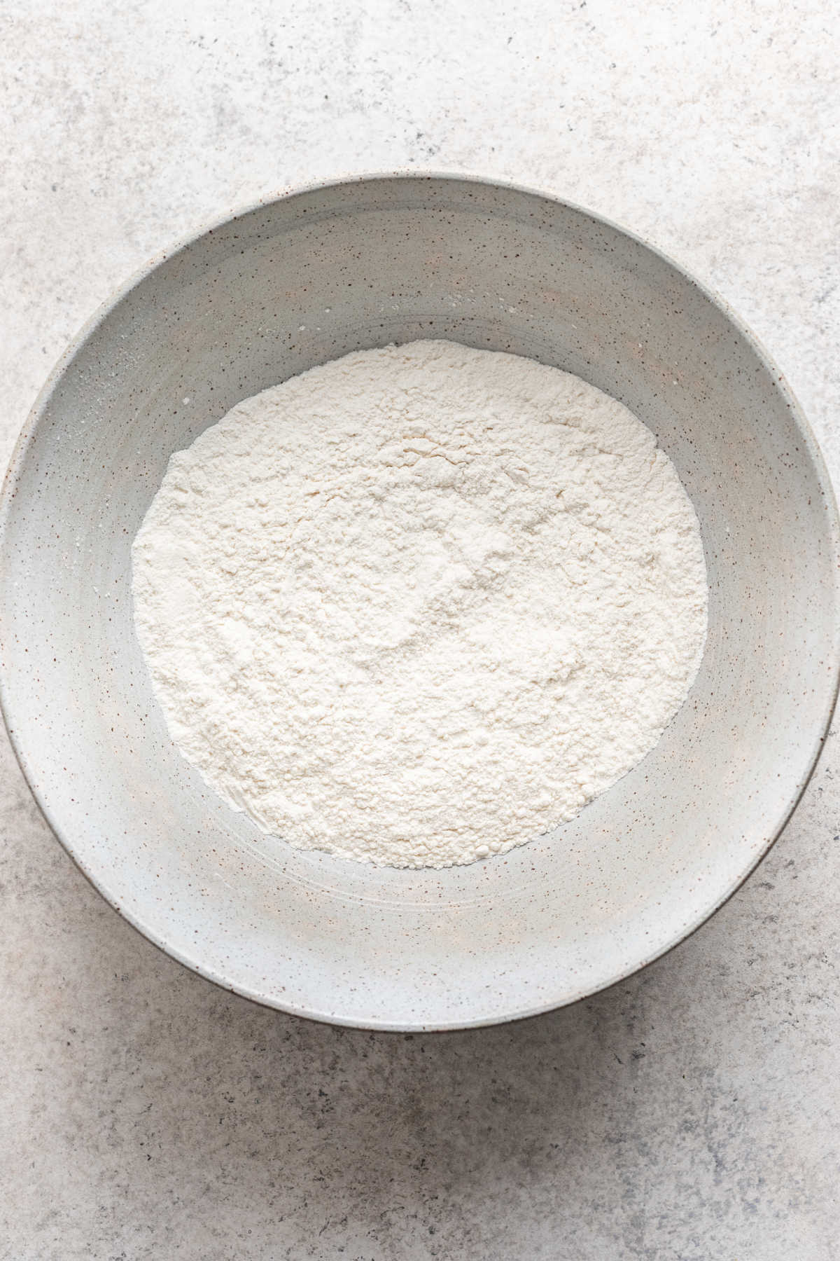 Dry ingredients for lemon ricotta pancakes in a mixing bowl.