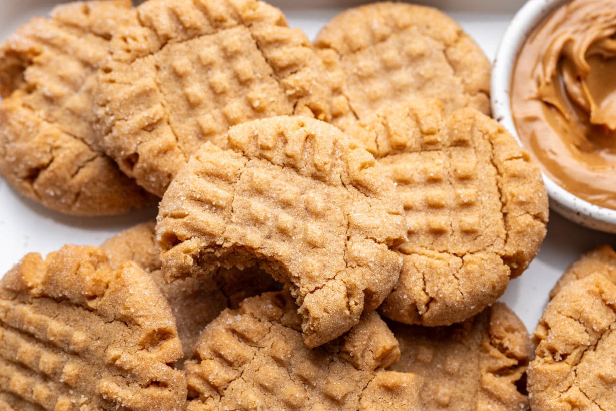 A peanut butter cookie with a bite missing on overlapping cookies.