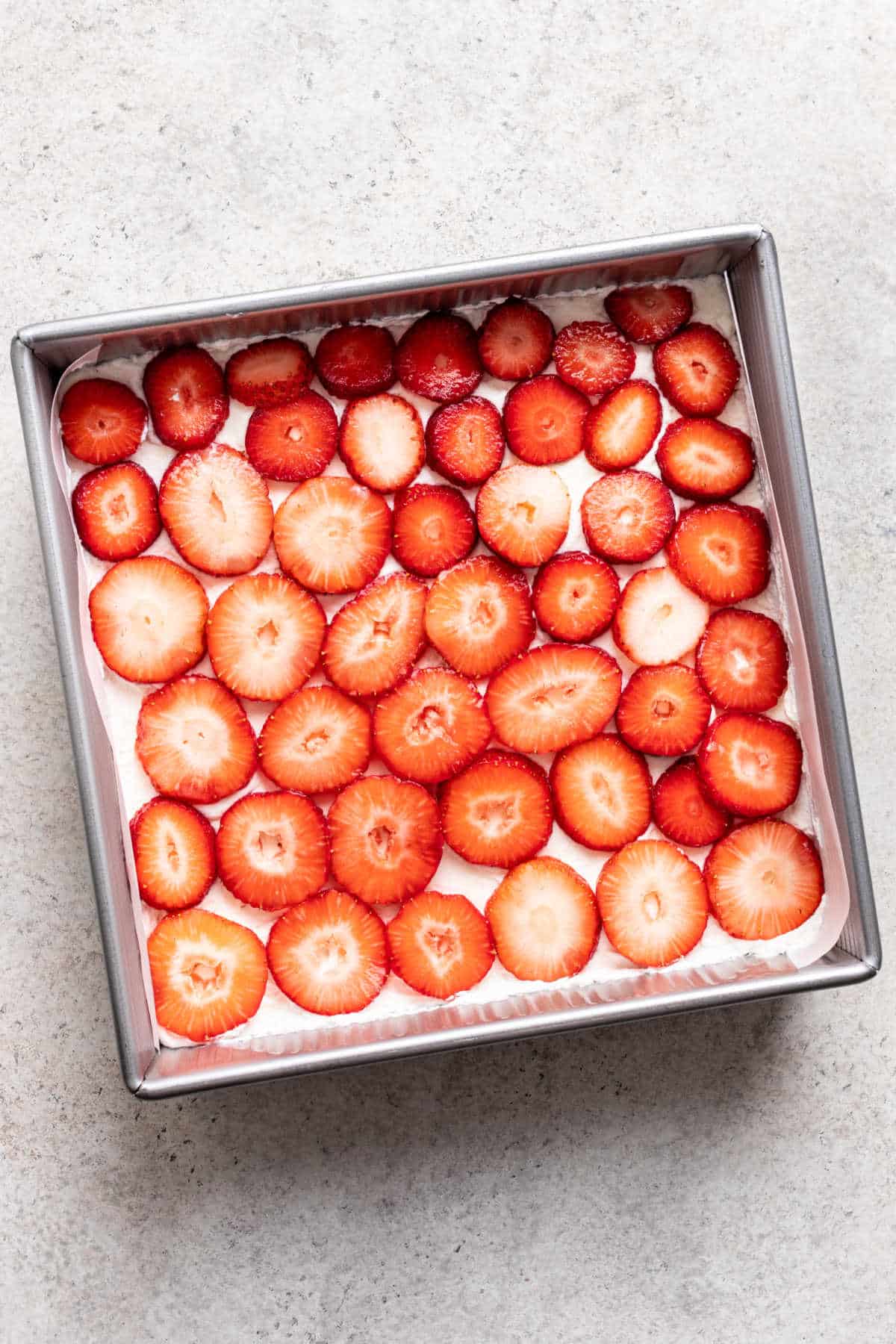 A layer of sliced strawberries over whipped cream cheese mixture. 