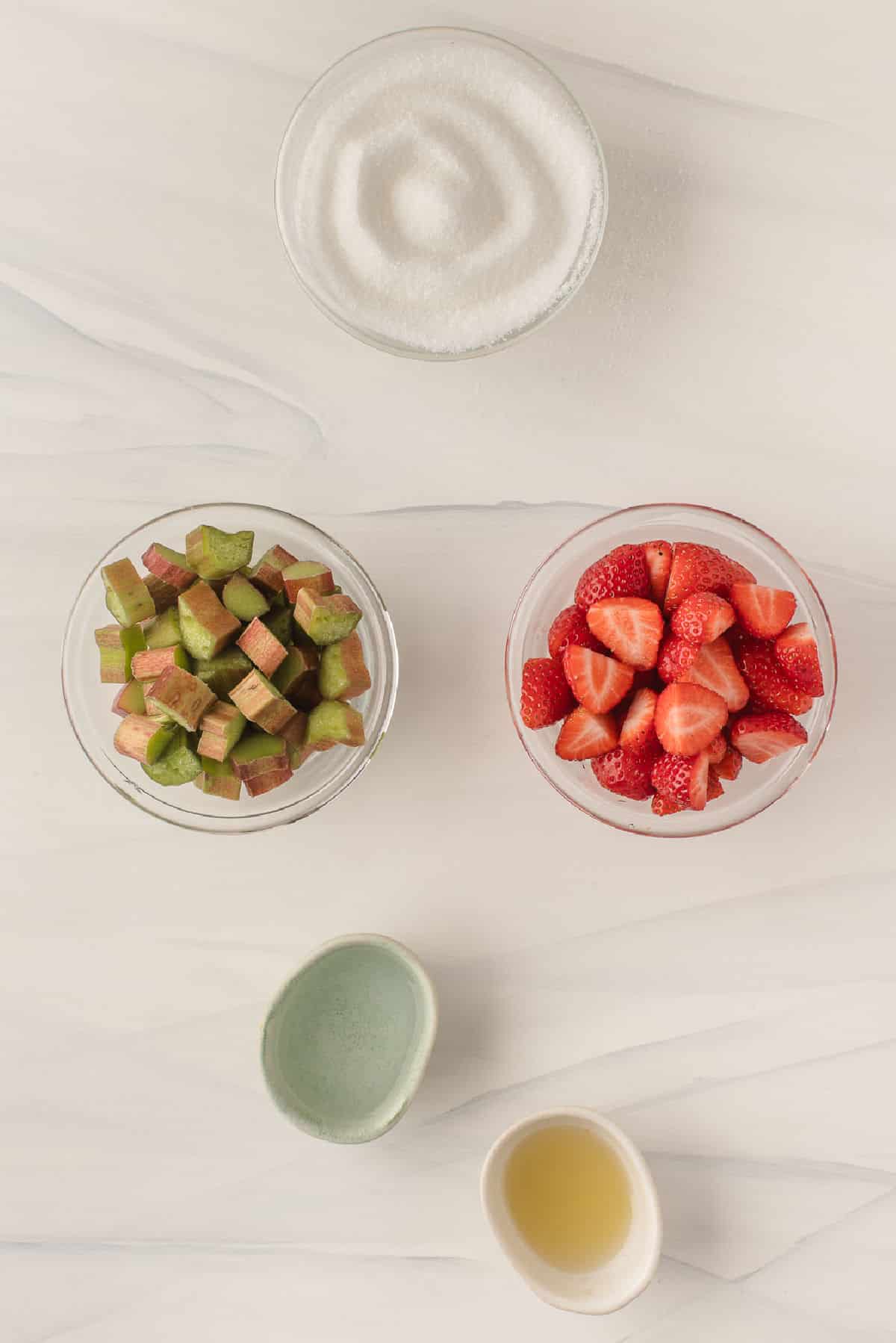 Ingredients for strawberry rhubarb jam in dishes. 