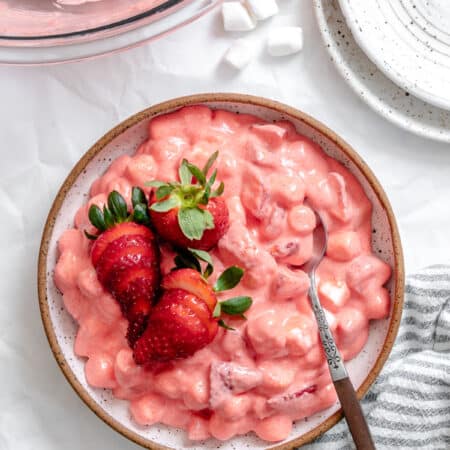 A dish of strawberry fluff topped with sliced fresh strawberries.