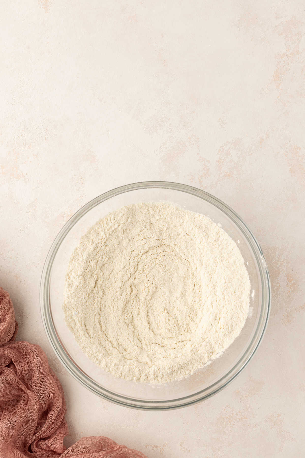 Dry ingredients for sweet cream pancakes in a glass mixing bowl.