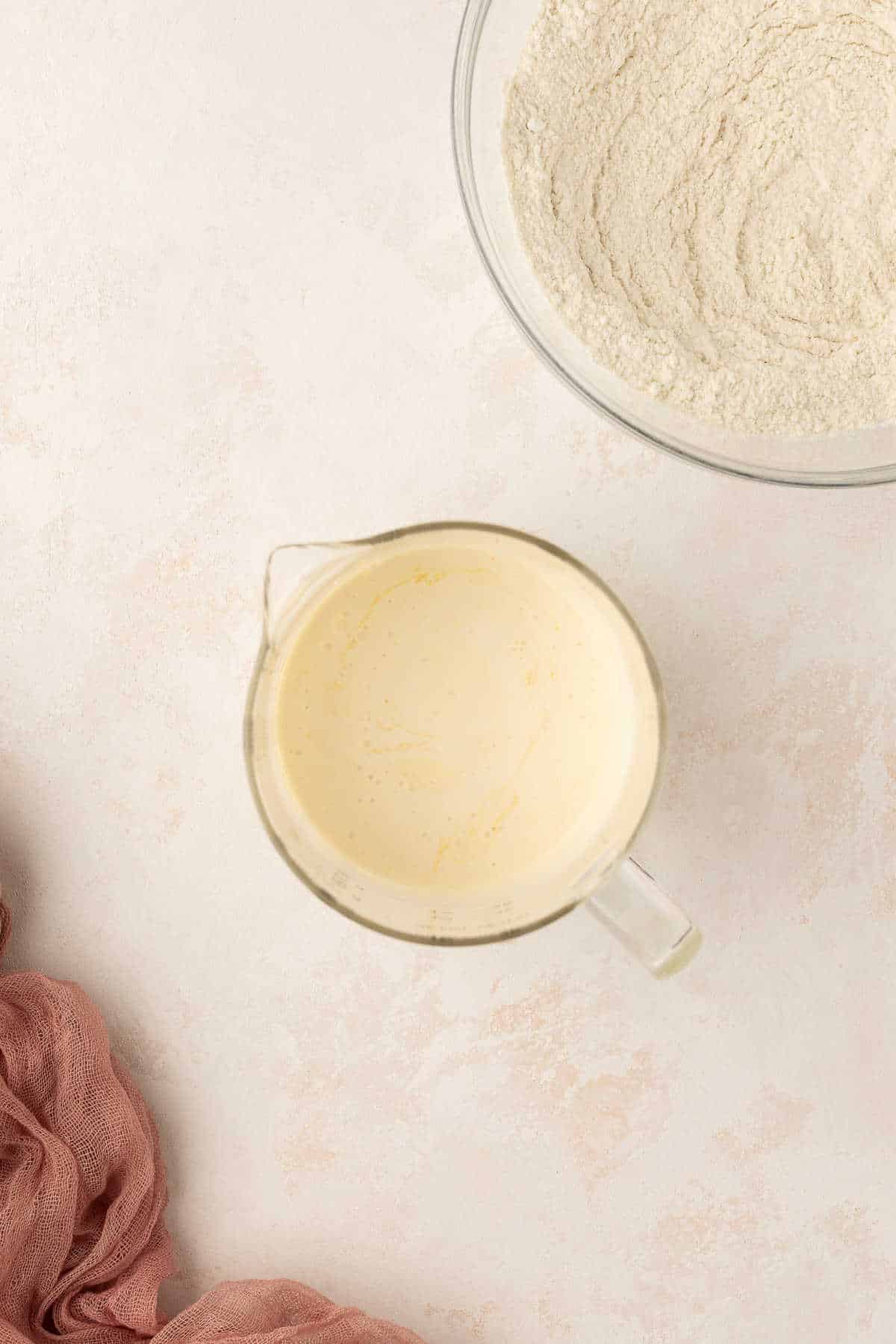 Wet ingredients for sweet cream pancakes in a glass measuring cup.