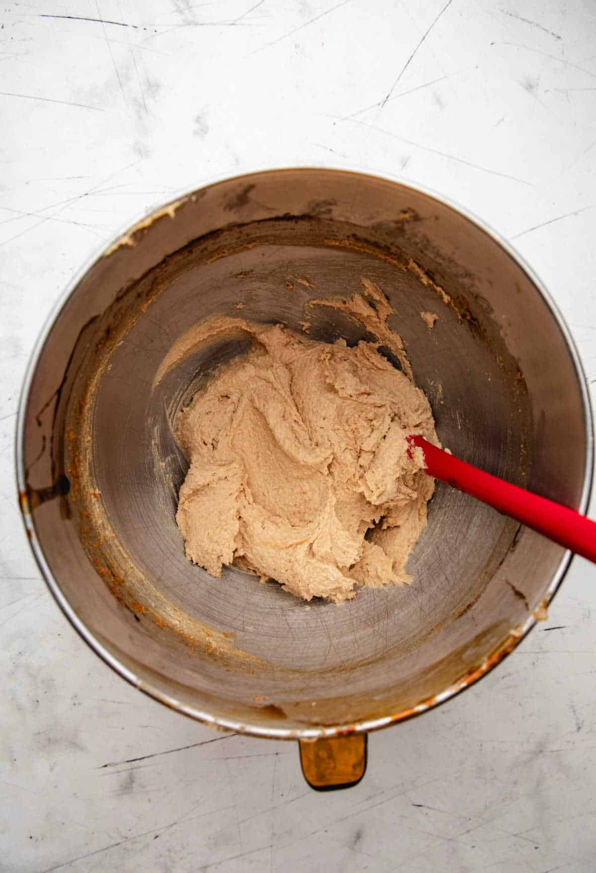 Creamed butter and sugars in a silver mixing bowl. 