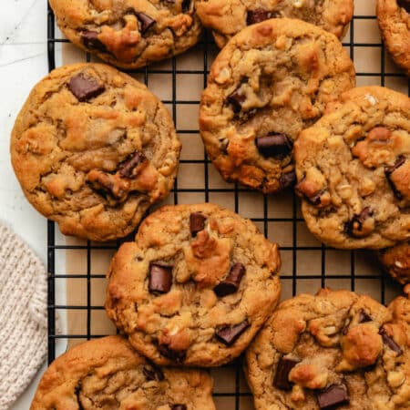 Overlapping Chick-fil-A chocolate chunk cookies on a wire cooling rack.