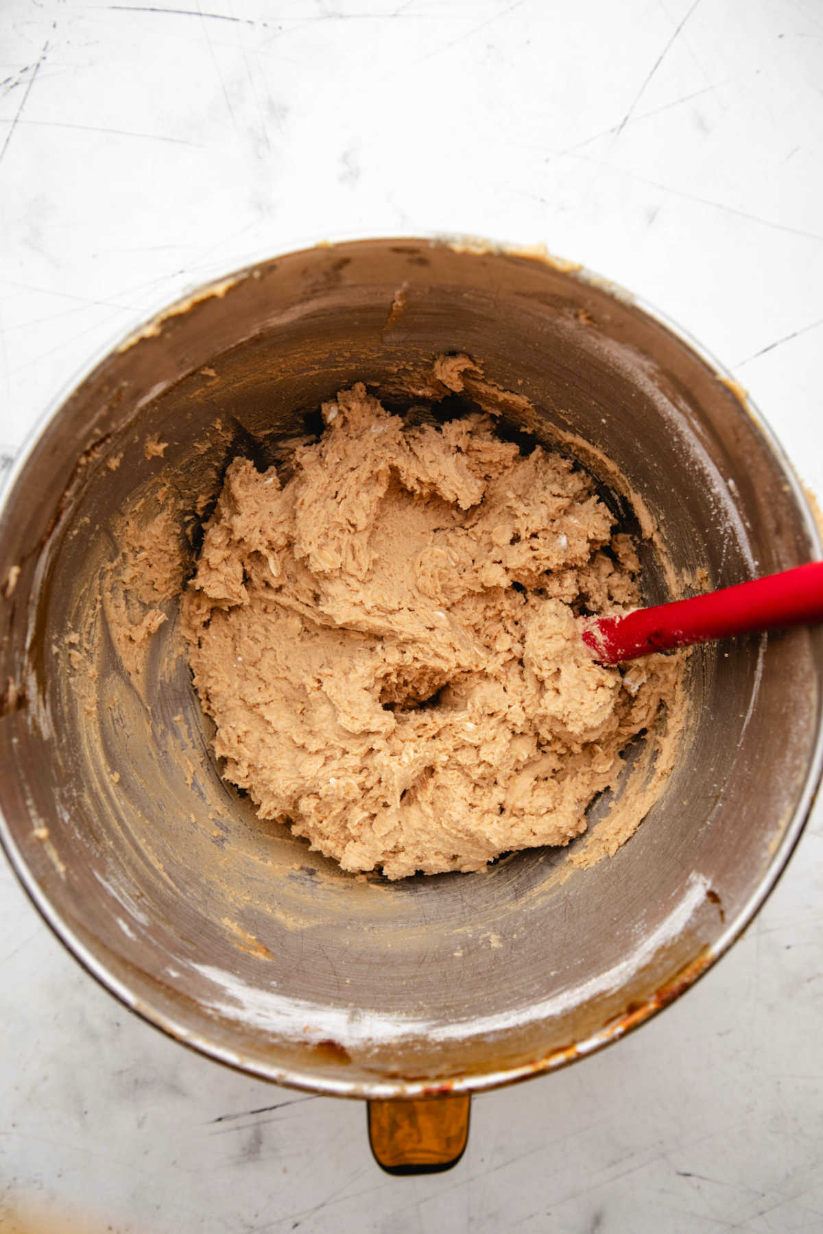 Chick fil a chocolate chunk cookie dough in a silver mixing bowl. 