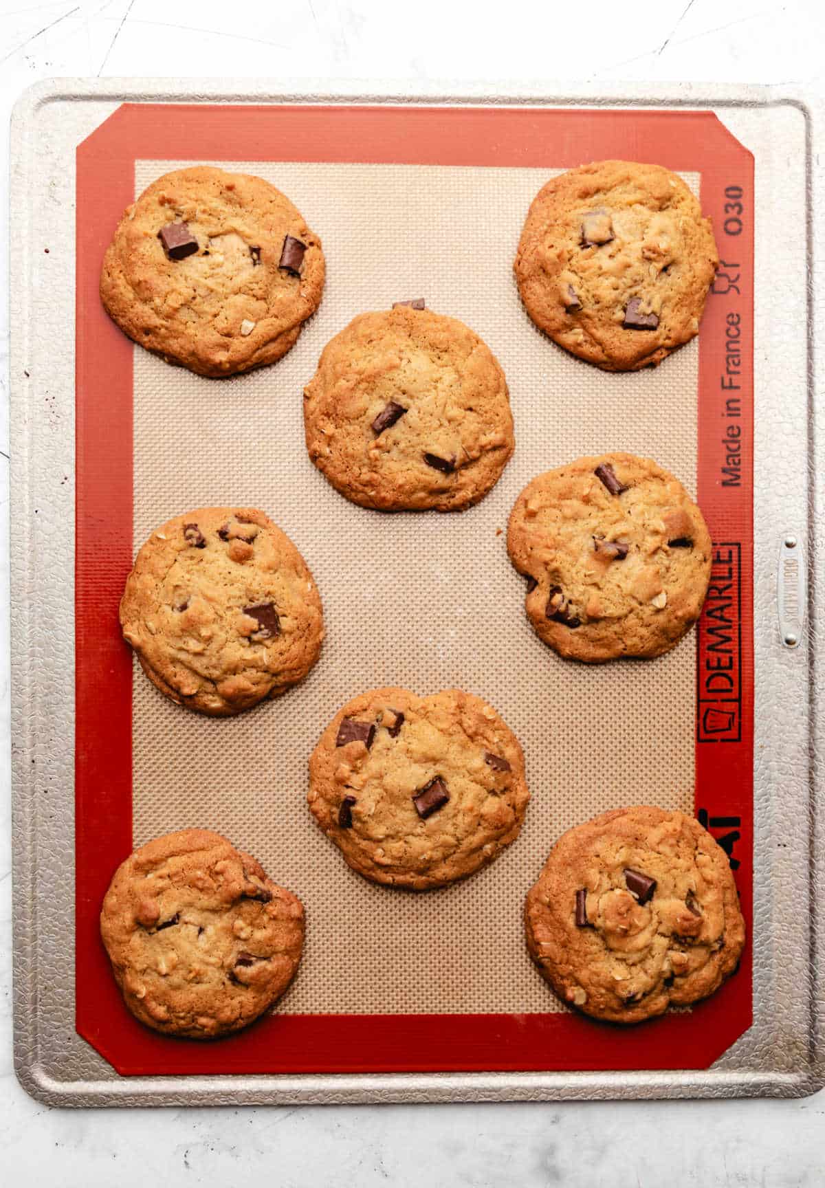 Baked chick-fil-a chocolate chunk cookies on a baking sheet. 