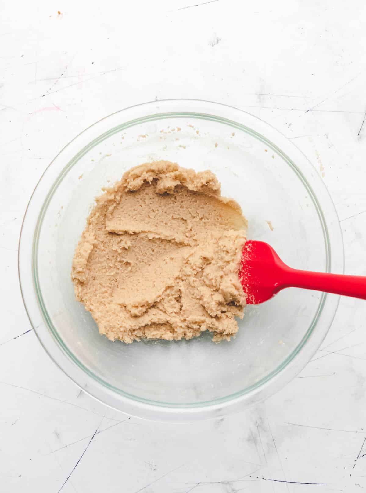 Creamed butter and sugars in a glass mixing bowl.