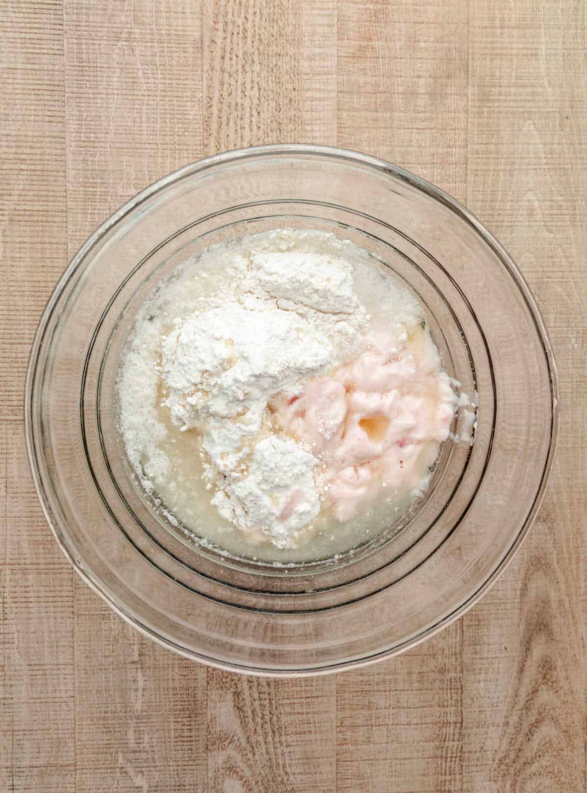 Ingredients for strawberry yogurt cake in a glass mixing bowl.