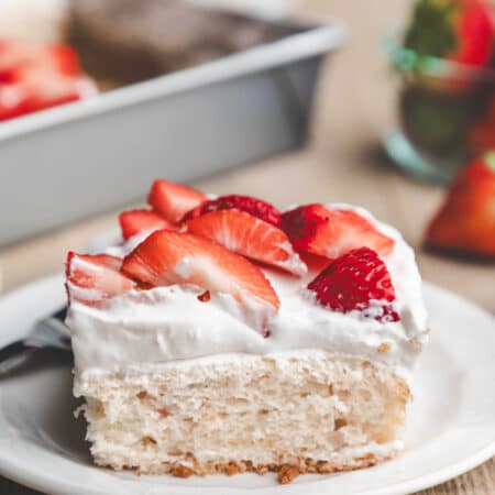 A slice of strawberry yogurt cake topped with fresh strawberry slices.