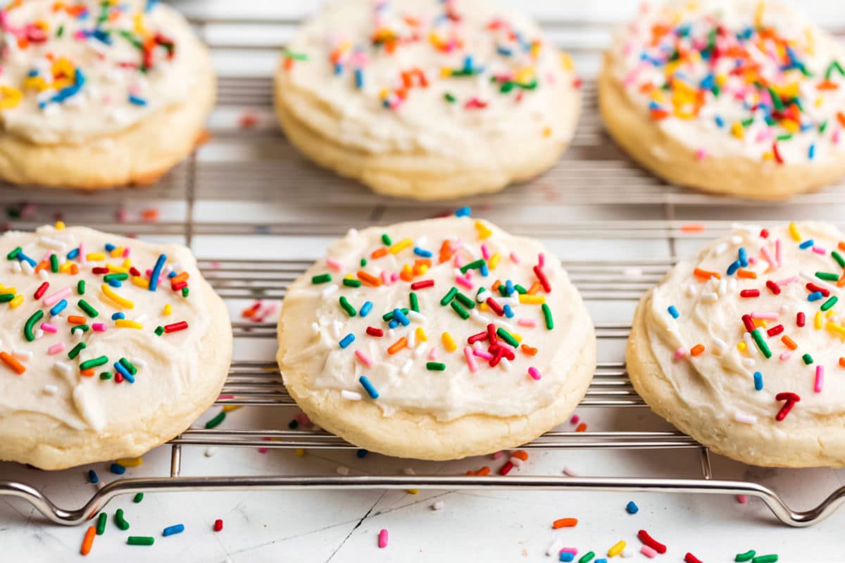 Rows of copycat Lofthouse cookies on a wire rack with sprinkles around them.