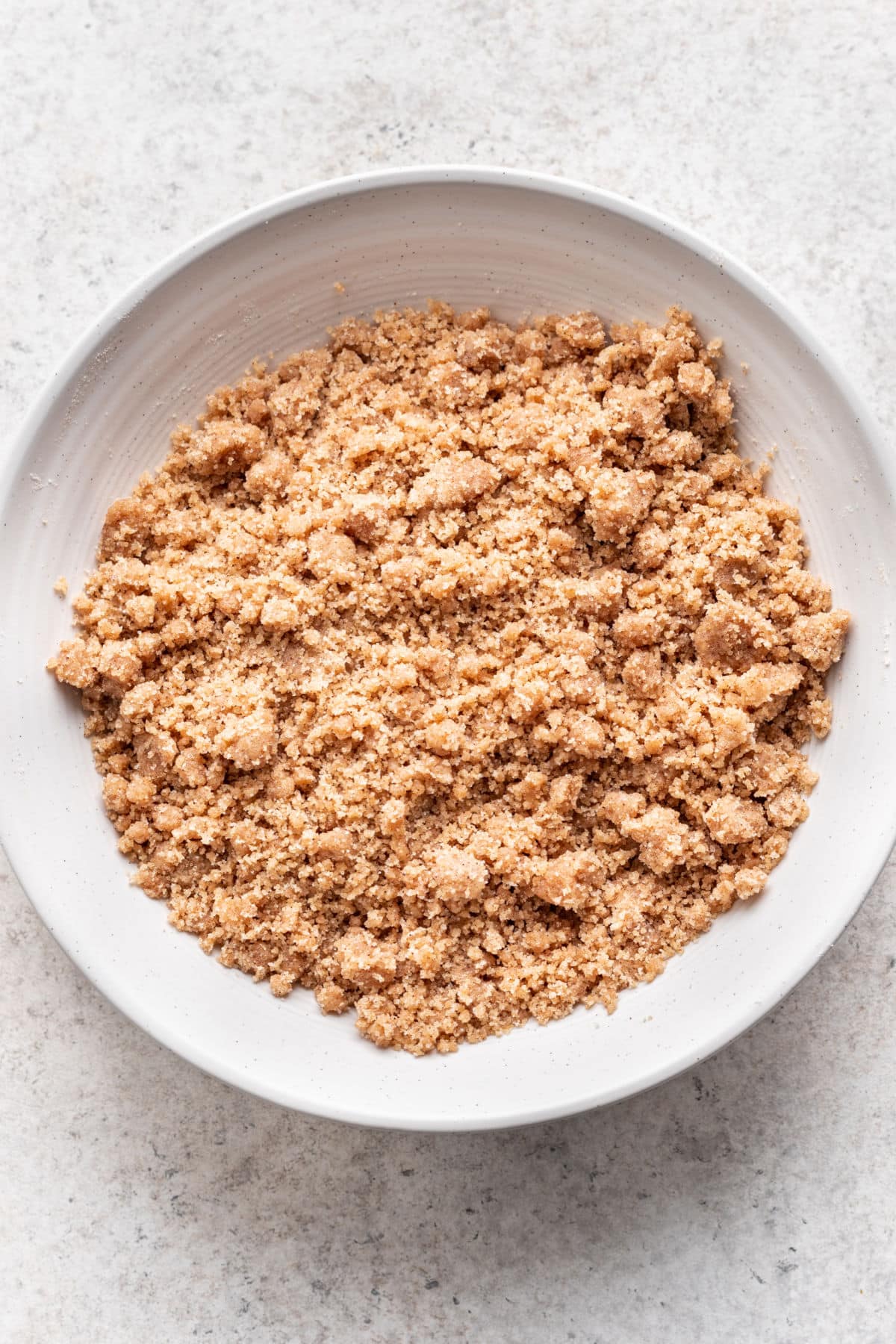 Garniture de crumble en sucre brun dans un bol à mélanger blanc.
