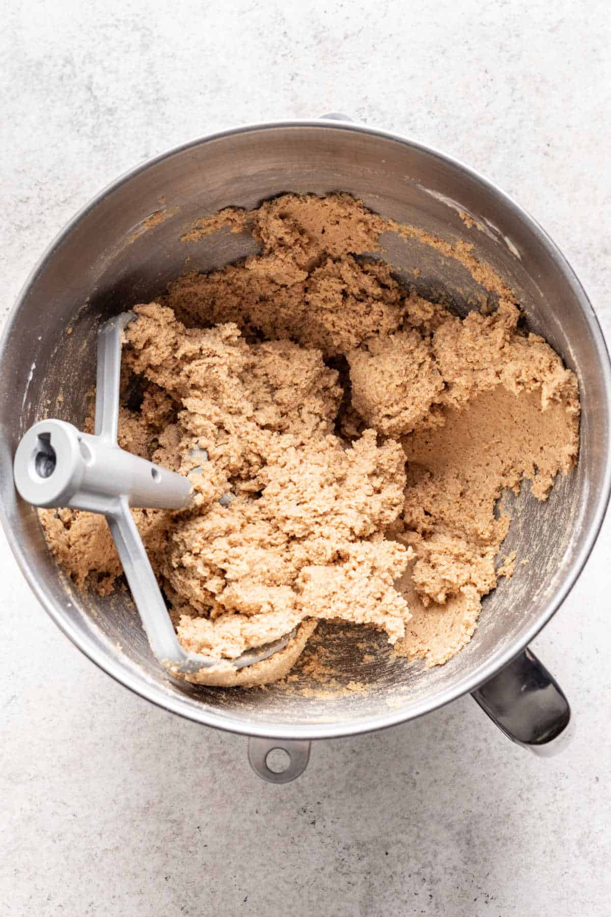 Graham cracker dough in a silver mixing bowl.