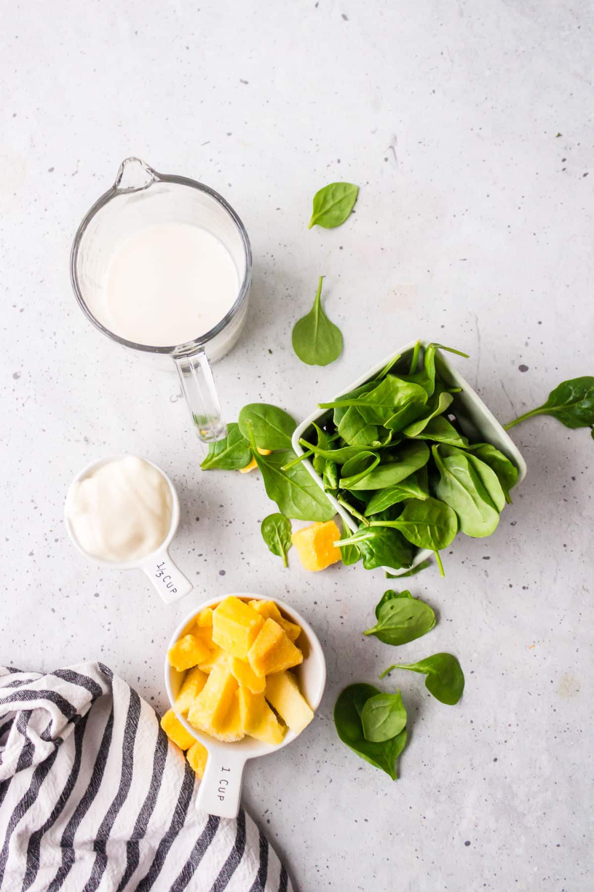 Ingredients for tropical green smoothie in dishes.