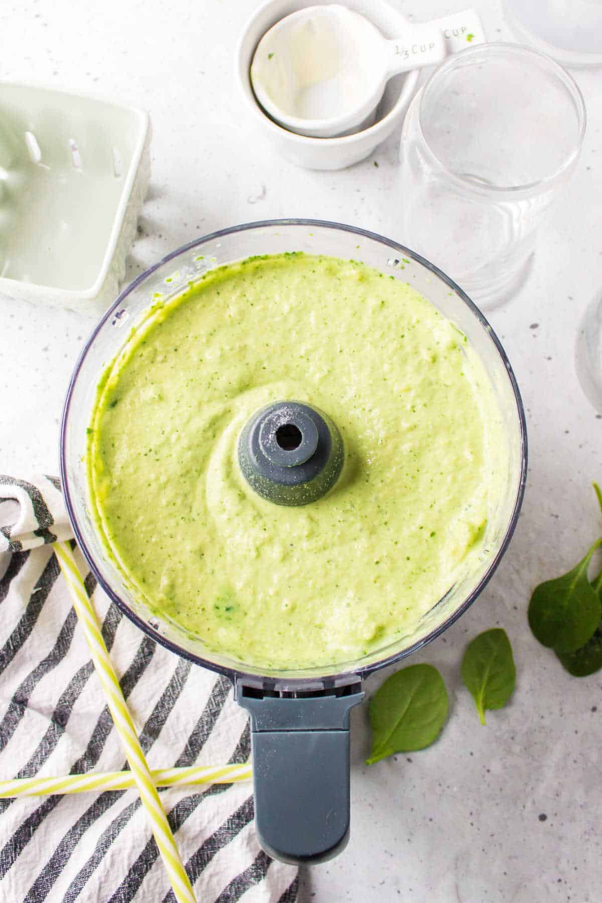 Blended tropical green smoothie in a food processor.