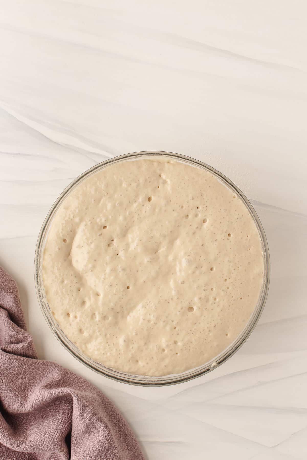 Rested crumpet mixture in a large mixing bowl.