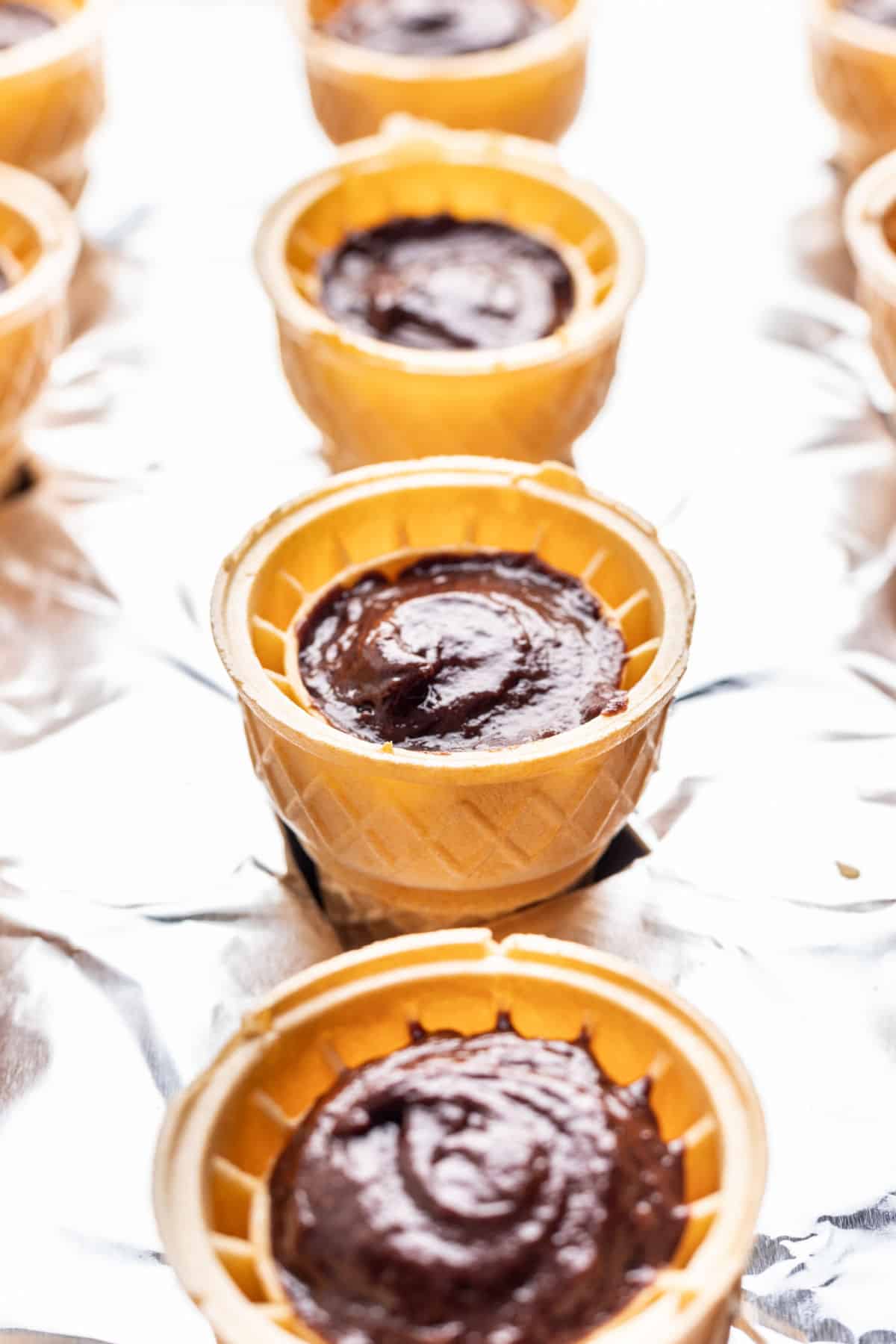 Ice cream cone cupcake batter in ice cream cones.