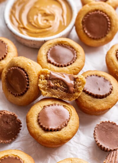 Half of a peanut butter cup cookie leaning against more cookies.