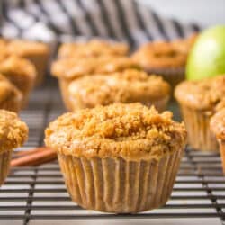 Apple muffins on a black wire cooling rack.