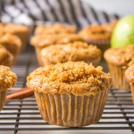 Apple muffins on a black wire cooling rack.
