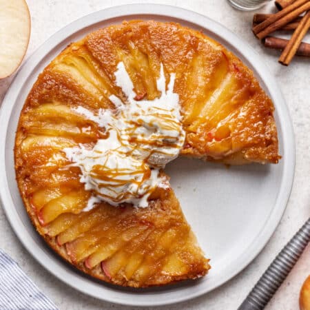 An apple upside down cake with a piece missing.