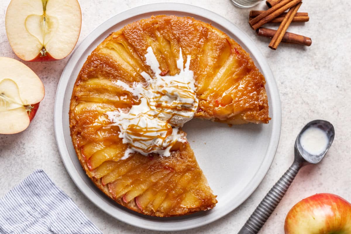 An apple upside down cake with a piece missing.
