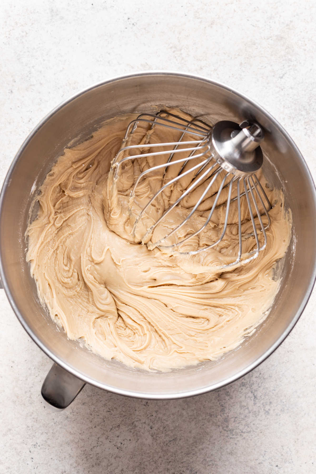 Caramel frosting in a silver mixing bowl.