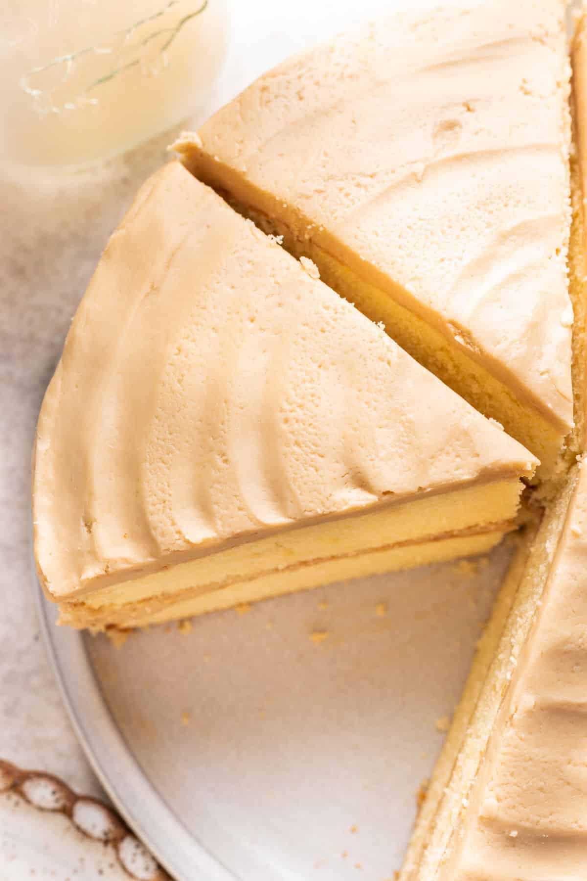 A cut piece of caramel cake against the cake.