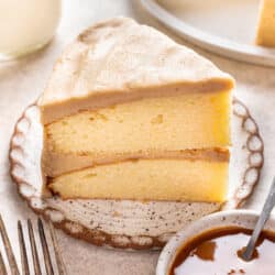 A slice of caramel cake next to the cake.