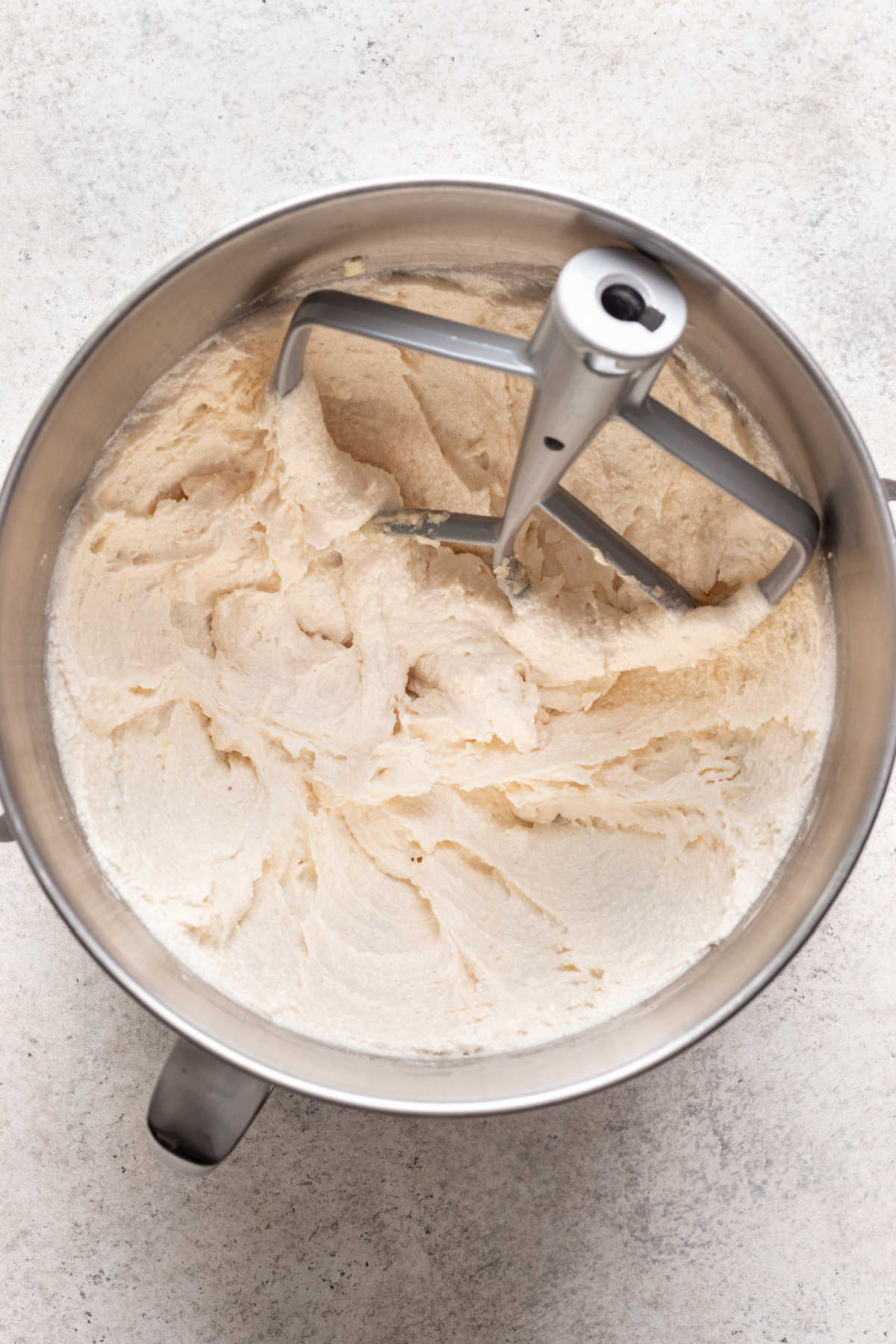Creamed butter and sugar in a silver mixing bowl.