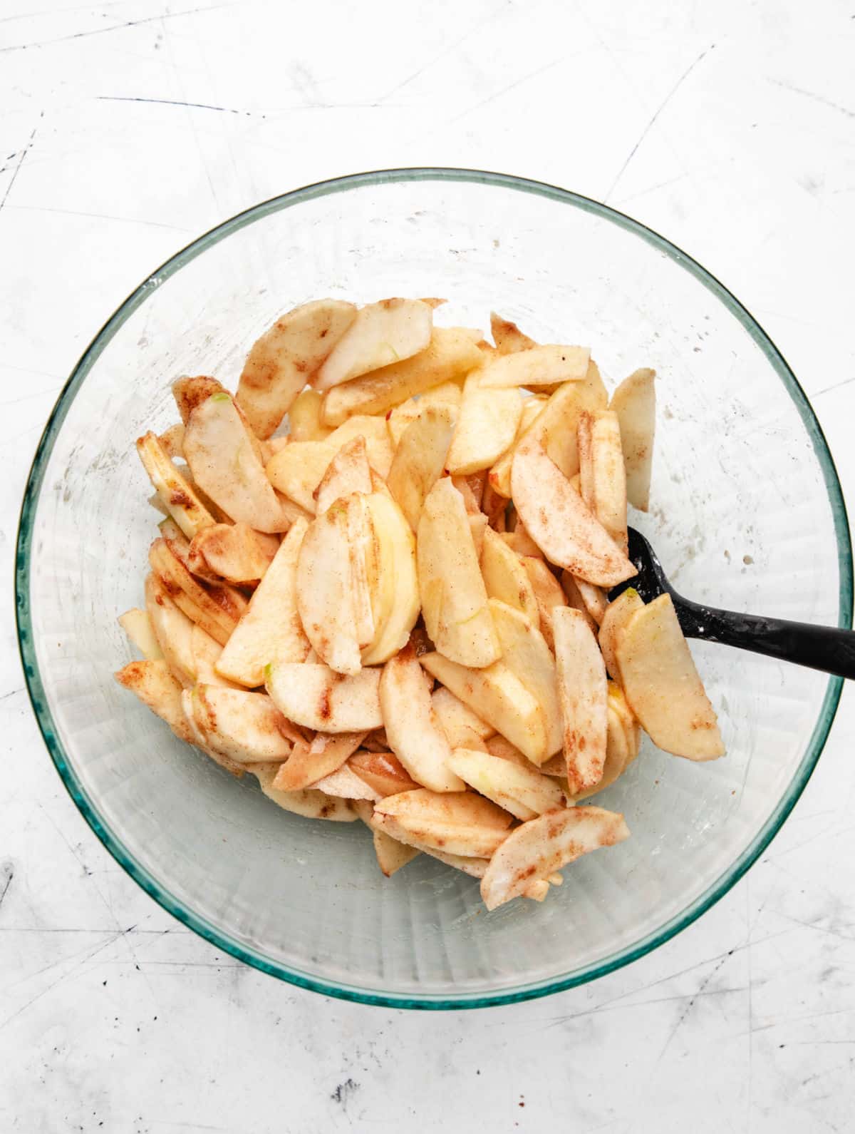 Apple filling ingredients in a glass mixing bowl.