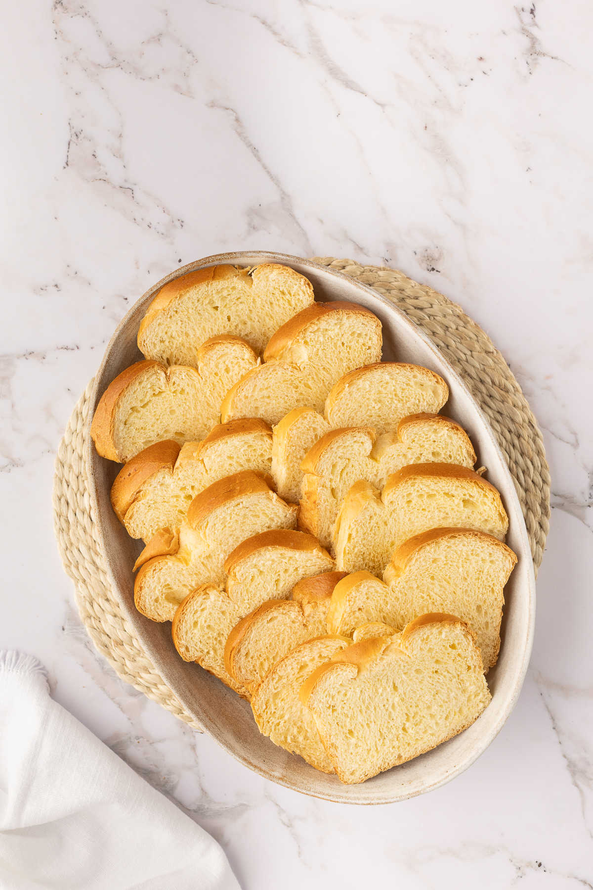 Slices of brioche bread overlapping in an oval baker.