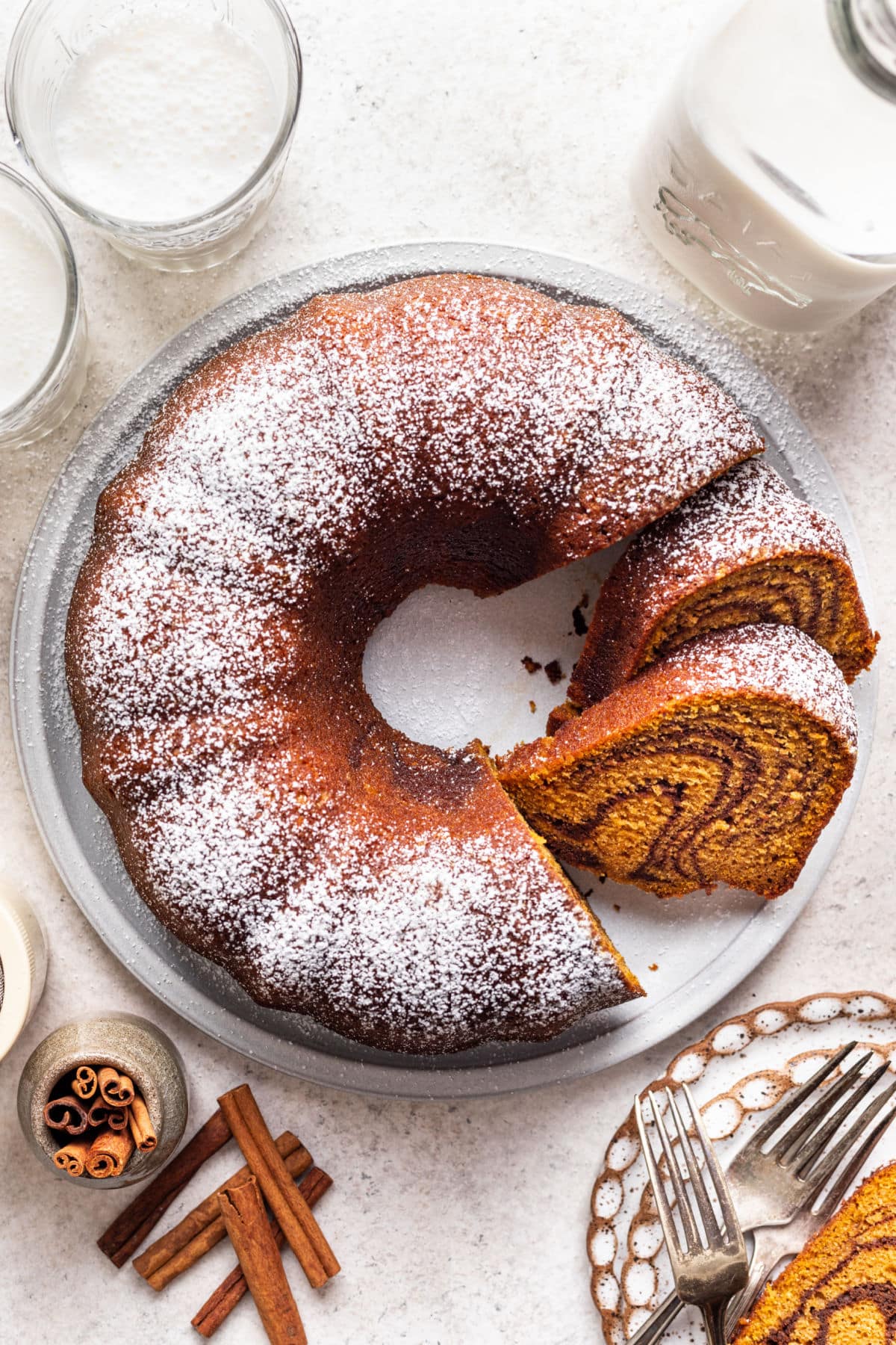 Pumpkin Marble Cake A cut pumpkin marble cake on a platter next to a plate with the slice of cake.