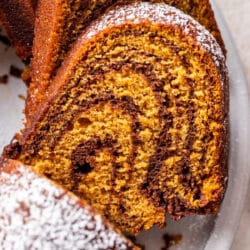 Close up slices of pumpkin marble cake on a white platter.
