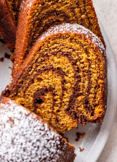 Close up slices of pumpkin marble cake on a white platter.