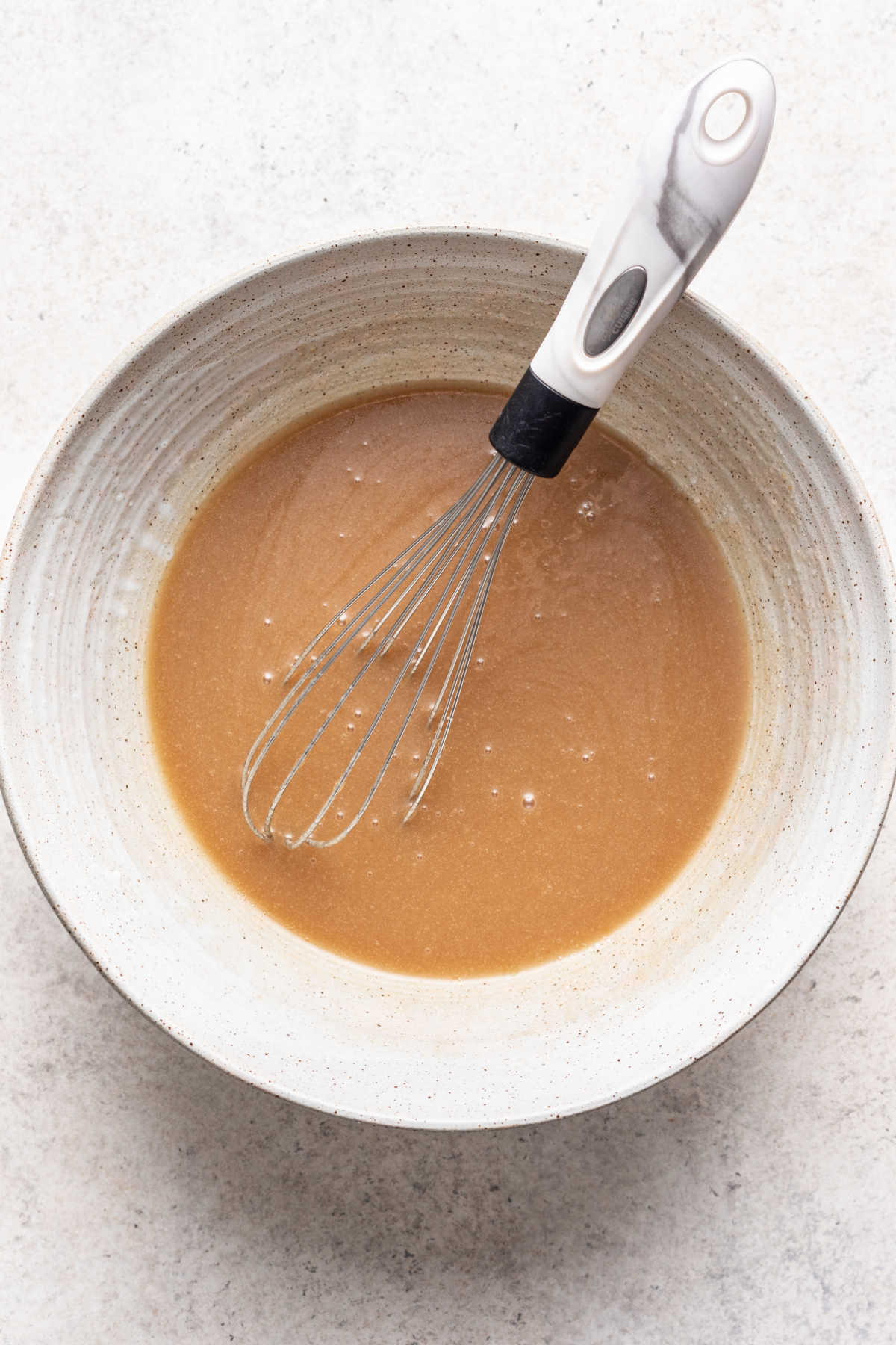 Sugars oil and buttermilk whisked together in a mixing bowl.