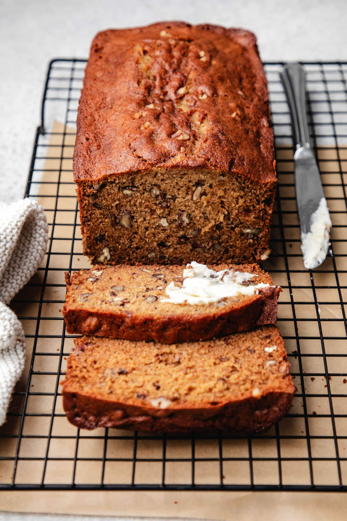 Two cut slices of date nut bread on a wire cooling rack.
