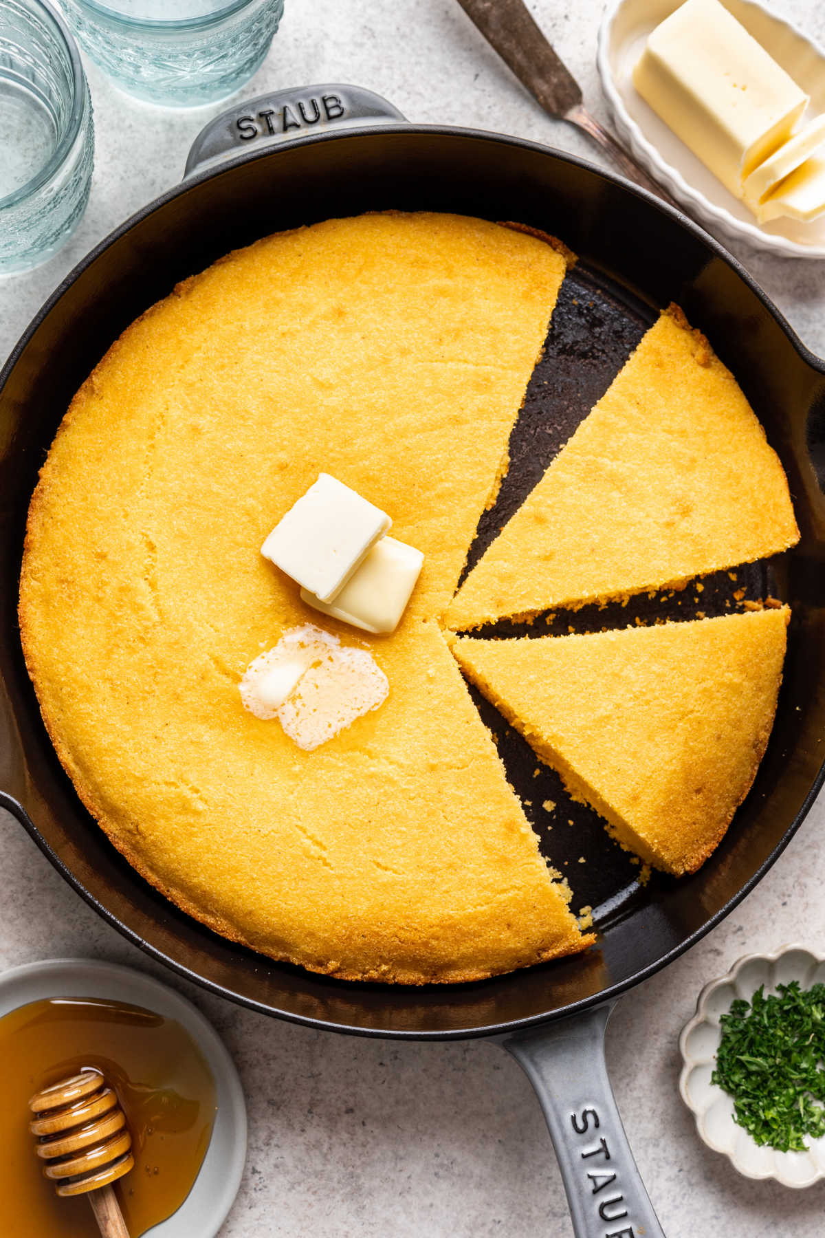 A pan of cornbread with two pieces cut.