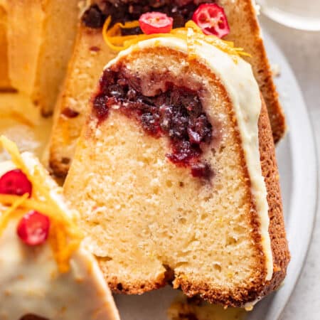 Slices of cranberry orange bundt cake leaning against each other on a platter.
