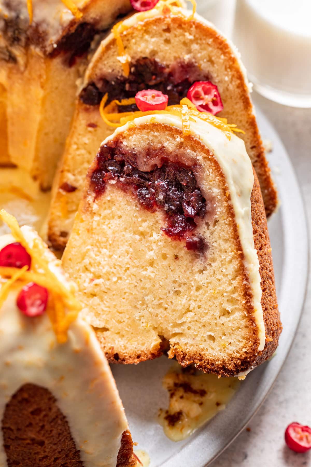 Cranberry Orange Cake Recipe Slices of cranberry orange bundt cake leaning against each other on a platter.