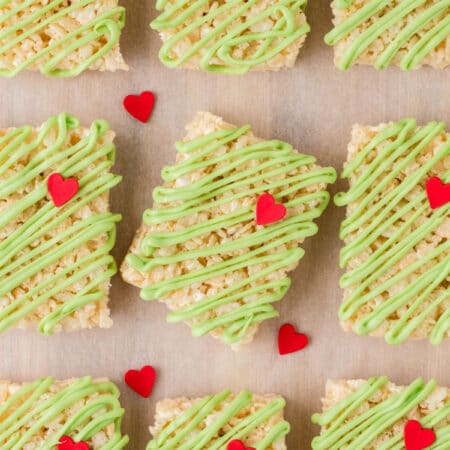 A row of Grinch Rice Krispies treats with the center one tilted.