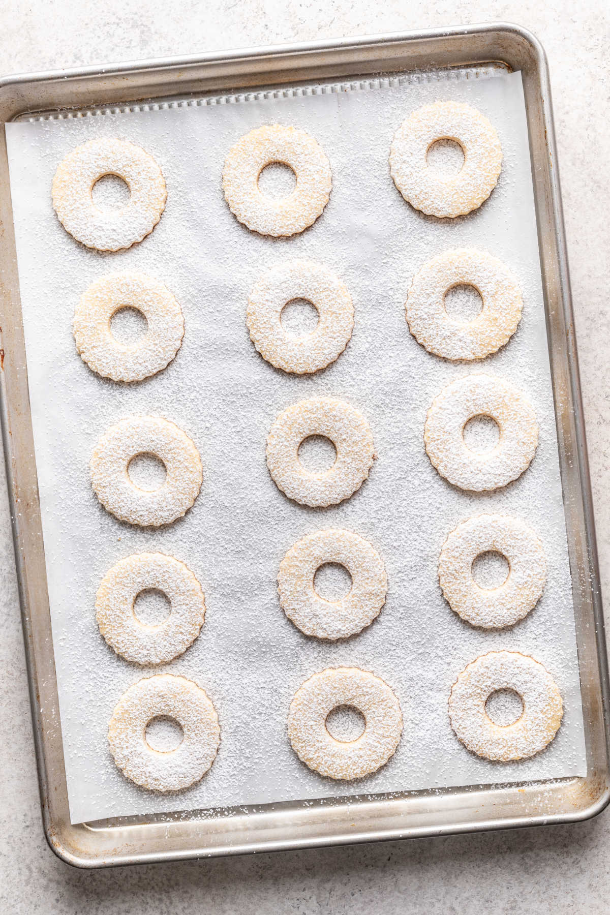 Linzer cookies with a cut out dusted with powdered sugar.