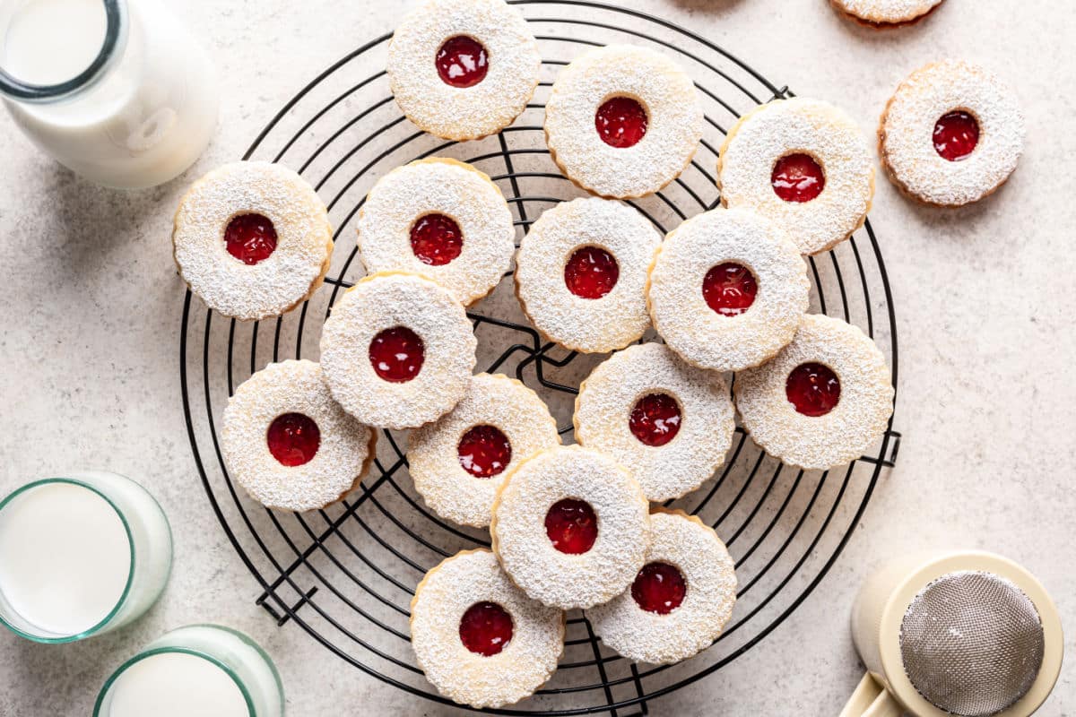 Linzer cookies next to a shaker of powdered sugar.