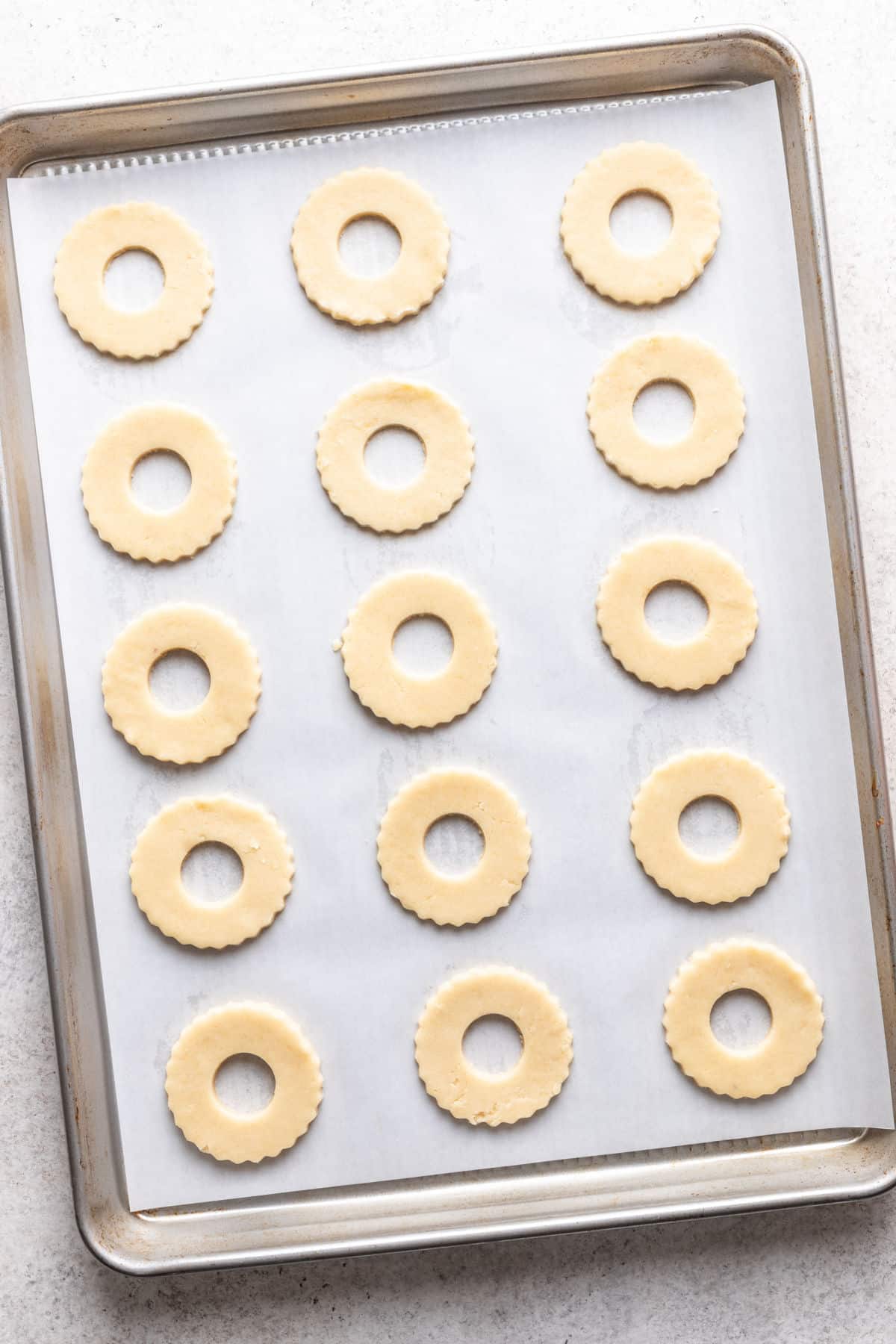 Linzer cookie dough circles with a hole cut in the center.