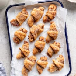 Cinnamon sugar rugelach in a parchment lined pan.