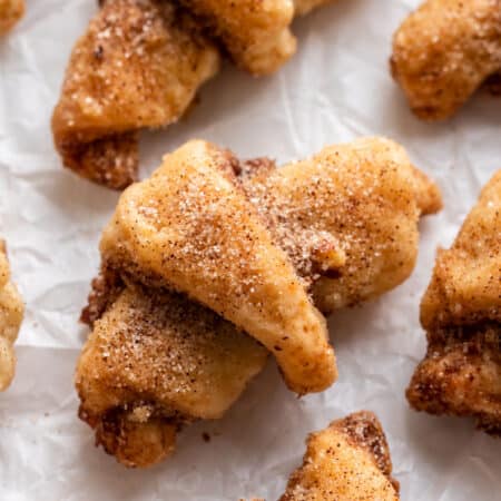 Cinnamon sugar rugelach in rows on parchment paper.