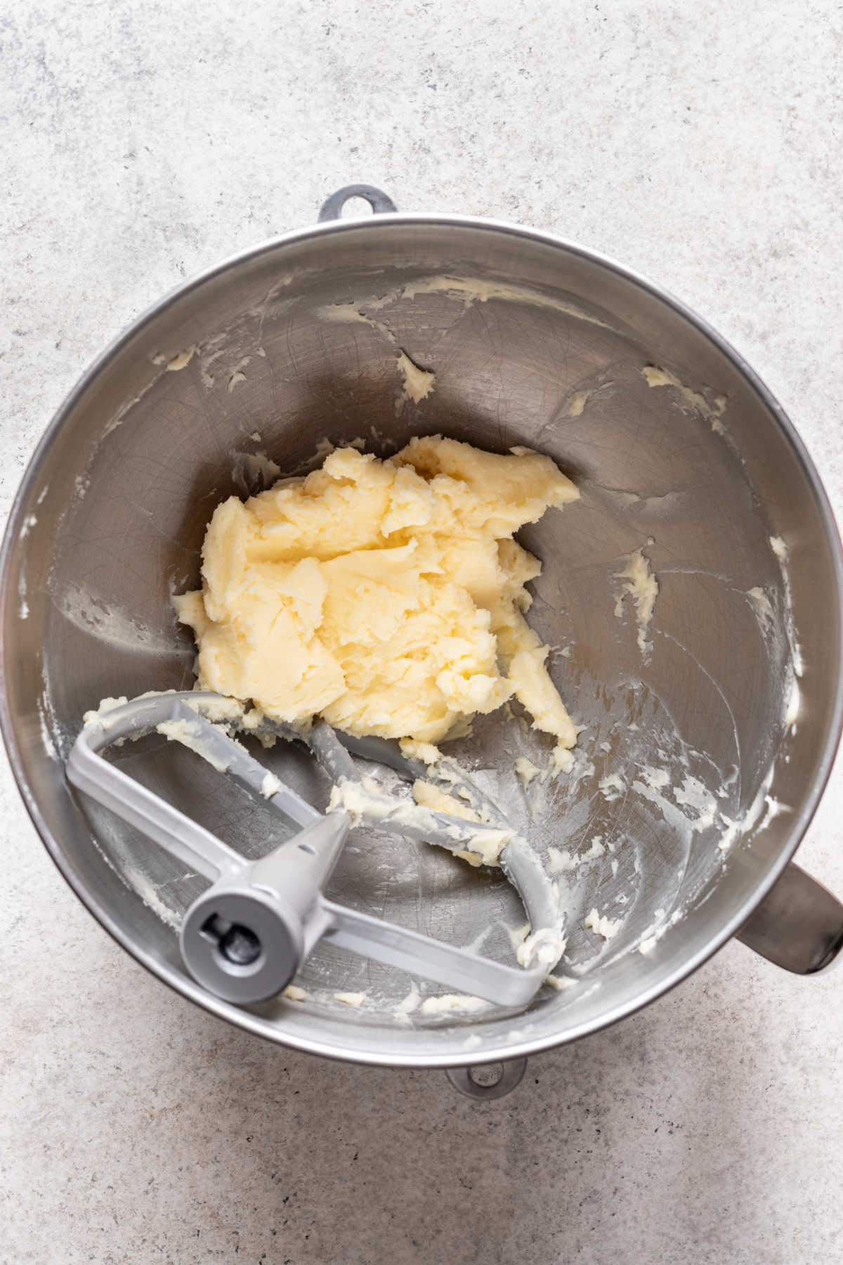 Butter and sugar beaten together in a silver mixing bowl.